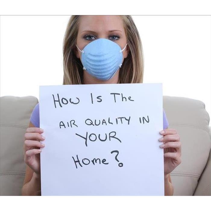 woman in medical mask asking 'how is the air quality in your home